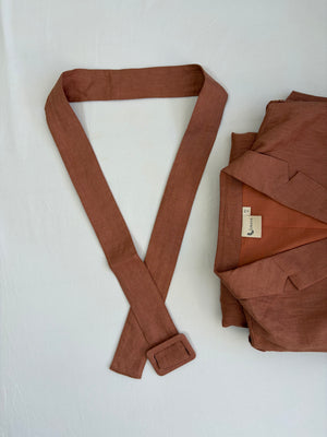 Brown fabric belt with buckle and folded brown fabric on a white background